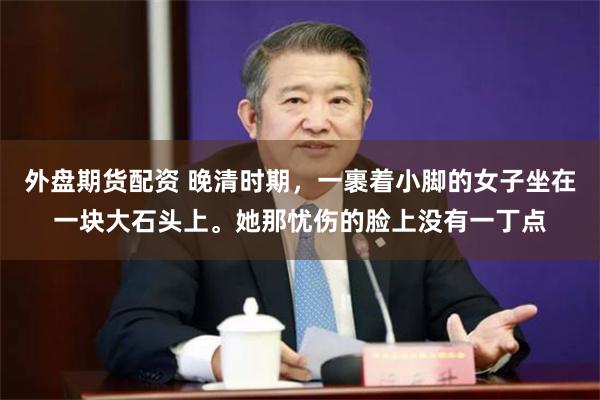 外盘期货配资 晚清时期，一裹着小脚的女子坐在一块大石头上。她那忧伤的脸上没有一丁点